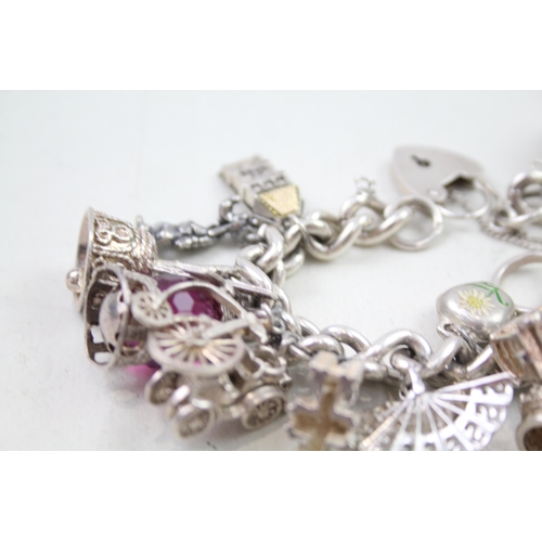 2310 - A silver charm bracelet with assorted charms - approx. gross weight 109g