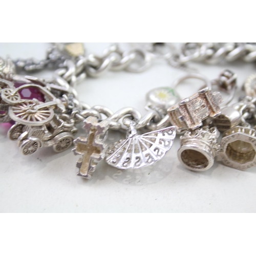 2310 - A silver charm bracelet with assorted charms - approx. gross weight 109g