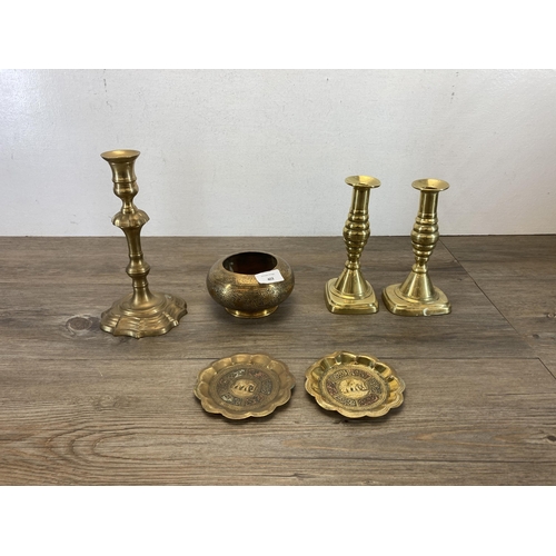 444 - Six pieces of brassware, three candlesticks - largest approx. 24cm high, pair of Middle Eastern 11.5... 