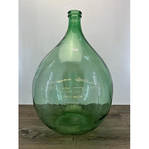 382 - A mid 20th century green glass carboy - approx. 65cm high