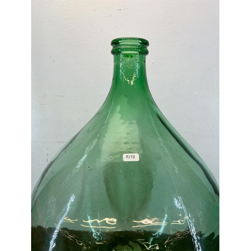 382 - A mid 20th century green glass carboy - approx. 65cm high