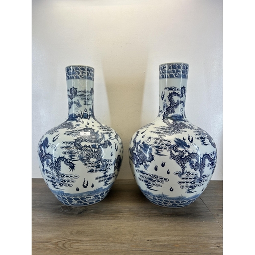 402 - A pair of Chinese blue and white porcelain dragon pattern bottle neck floor vases with Qianlong six ... 