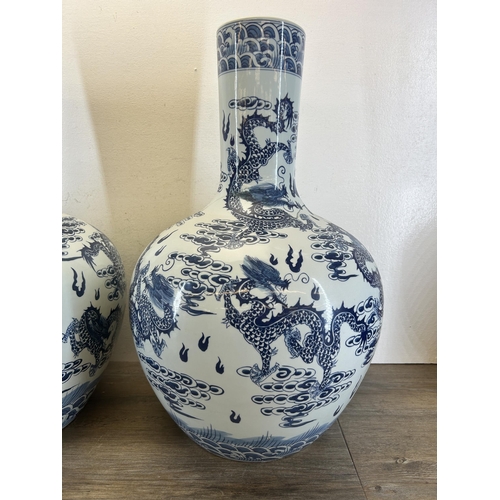 402 - A pair of Chinese blue and white porcelain dragon pattern bottle neck floor vases with Qianlong six ... 