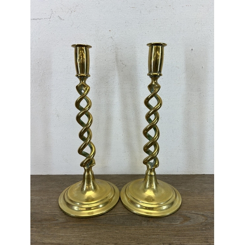 426 - Three pieces of brassware, two barley twist candle sticks - approx. 31cm high and one engraved tray ... 