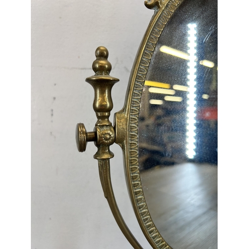 427 - A Rococo style brass framed oval swing mirror - approx. 49cm high x 30cm wide