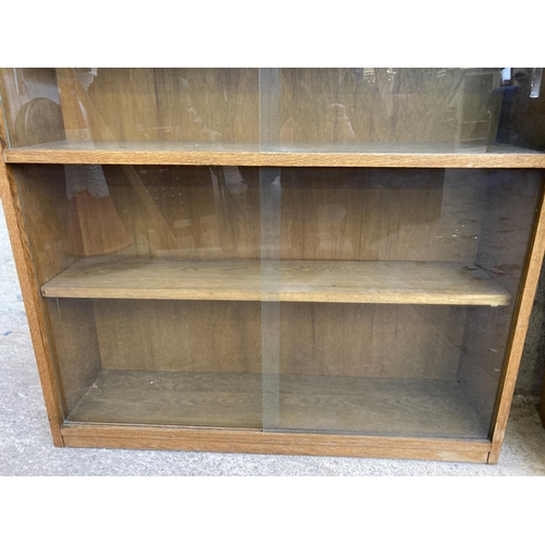 1 - A mid 20th century oak three tier bookcase with four glass sliding doors - approx. 92cm high x 91cm ... 