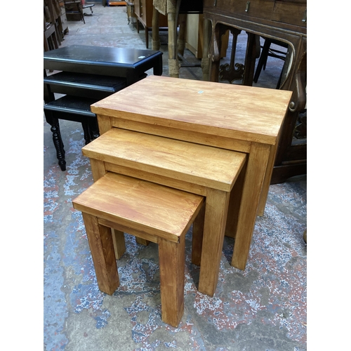 122 - Two modern nests of tables, one black painted and one stained beech