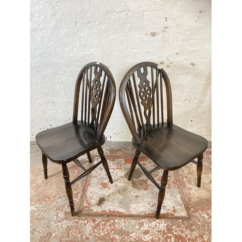147 - Four beech wheelback dining chairs