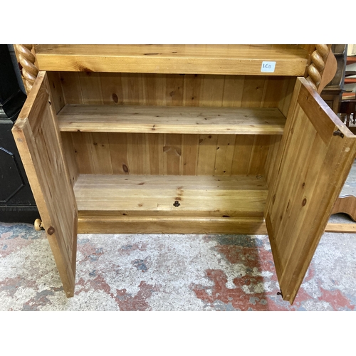 15 - A modern pine three tier open bookcase with two lower cupboard doors and barley twist design - appro... 