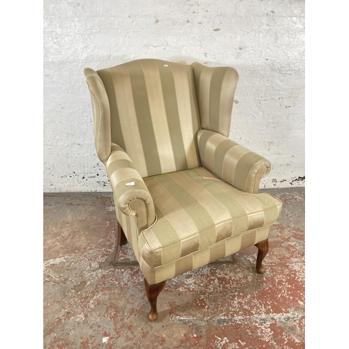 159 - A Georgian style fabric upholstered wingback armchair on cabriole supports