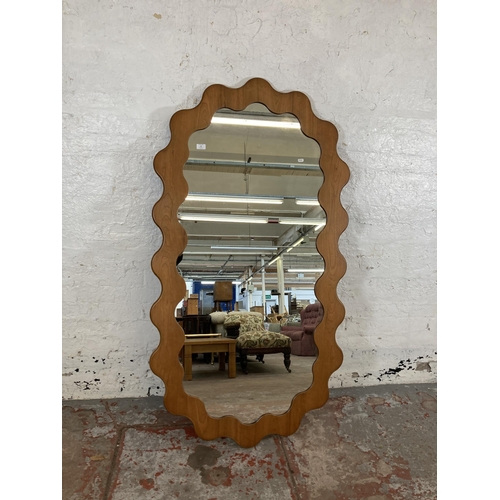 16 - An Urban Outfitters Sofia cherry wood framed wall mirror - approx. 165cm high x 89cm wide