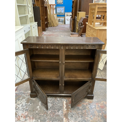 30 - A mid 20th century carved oak bookcase with two lead glazed cupboard doors - approx. 100cm high x 10... 