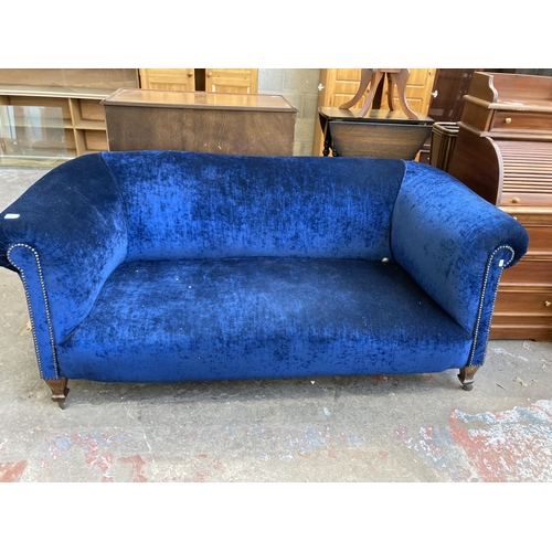 42 - A Victorian blue fabric upholstered two seater sofa on inlaid mahogany supports and later added cast... 