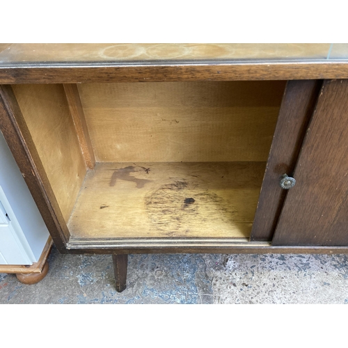 53 - A mid 20th century oak veneer display cabinet with two glass sliding doors