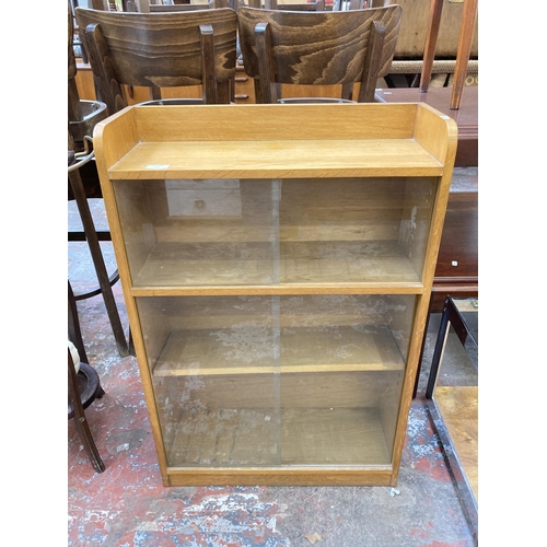 71 - A mid 20th century oak four tier book case with four glass sliding doors - approx. 92cm high x 61cm ... 