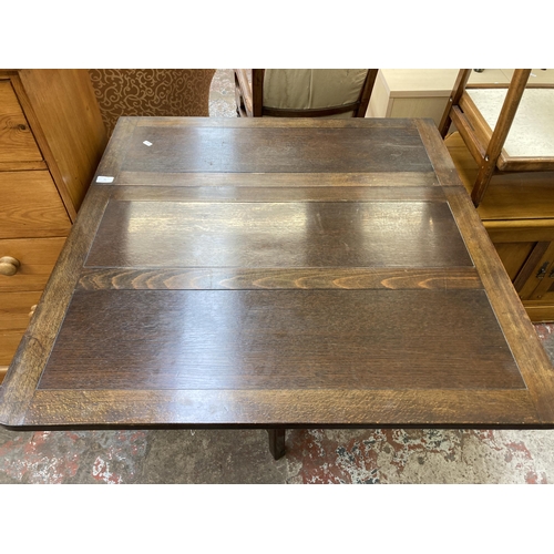 76 - A mid 20th century oak drop leaf gate leg dining table - approx. 76cm high x 90cm wide x 152cm long