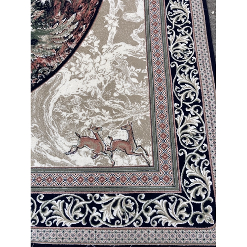 86 - A modern blue floral bordered rug with central portrait - approx. 400cm x 300cm