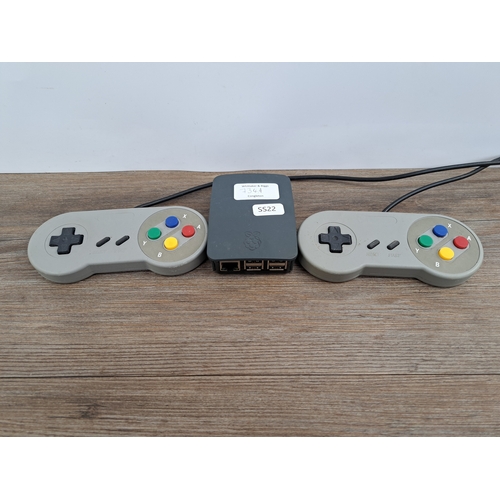 734A - A Raspberry Pi Model B+ computer with official case together with two unbranded SNES style USB contr... 