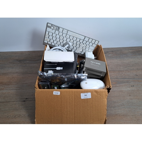 765 - A box containing computing items and accessories to include Apple mouse and keyboard, Apple plug and... 