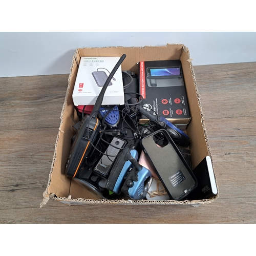 772 - A box containing communication items to include power banks, walkie talkies, battery extender cases ... 