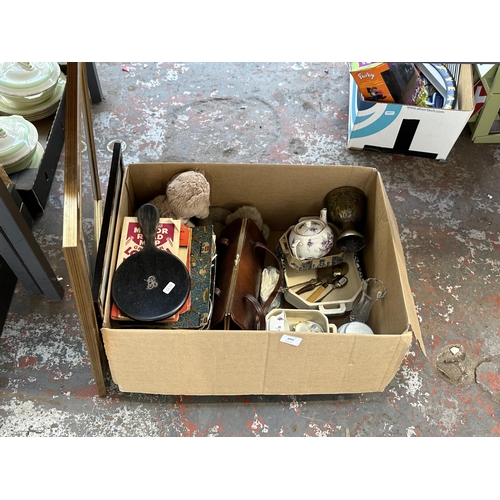 1010 - A box containing items to include hallmarked Sheffield silver teaspoon, ebony hand mirror with silve... 