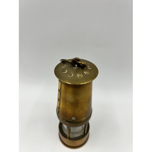 442 - A miniature brass miner's lamp - approx. 13cm high