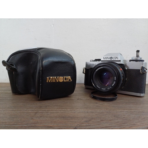 619 - A cased Minolta XG-1 35mm SLR camera fitted with MD 50mm 1:1.7 lens