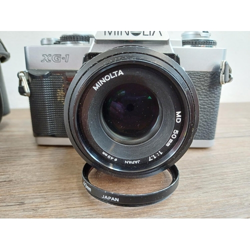 619 - A cased Minolta XG-1 35mm SLR camera fitted with MD 50mm 1:1.7 lens