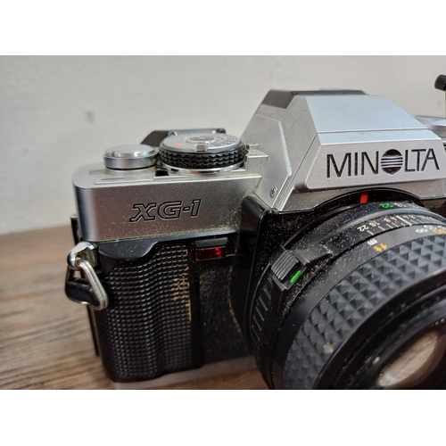 619 - A cased Minolta XG-1 35mm SLR camera fitted with MD 50mm 1:1.7 lens