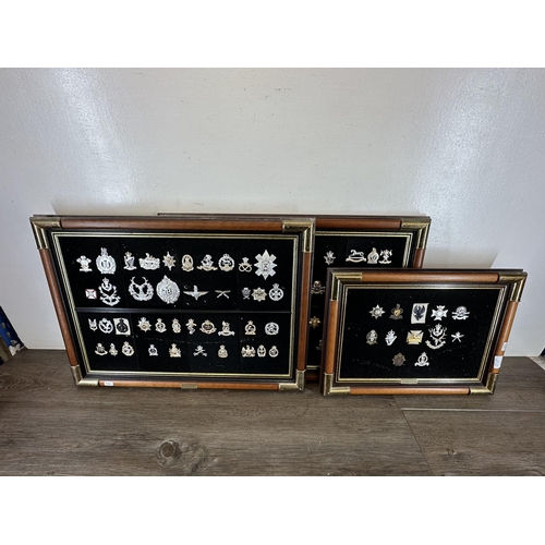 2232D - Three mahogany and gilt metal framed collections of military cap badges