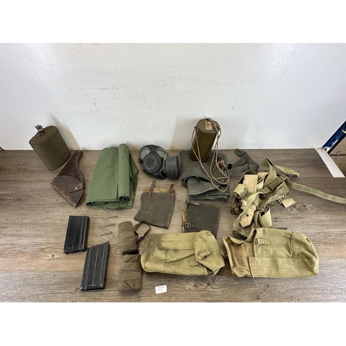 2232H - A collection of militaria to include L1A1 SLR magazines, WWII gas mark, water canteen etc.