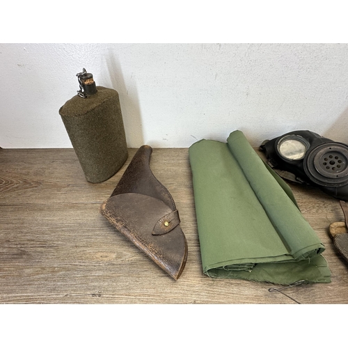 2232H - A collection of militaria to include L1A1 SLR magazines, WWII gas mark, water canteen etc.