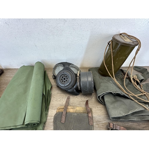 2232H - A collection of militaria to include L1A1 SLR magazines, WWII gas mark, water canteen etc.