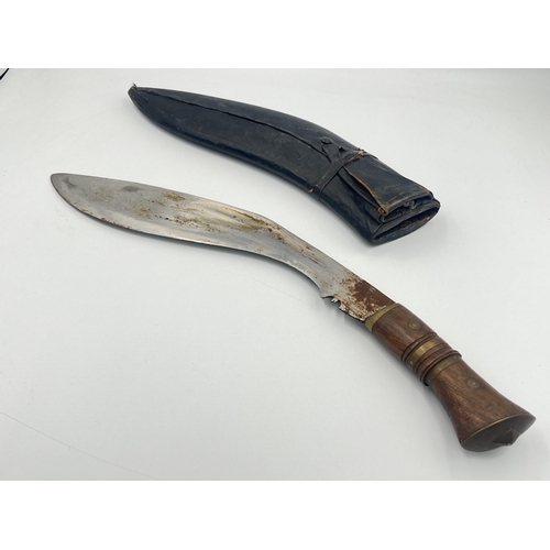 2232A - A vintage Kukri knife with leather sheath and brass and mahogany handle