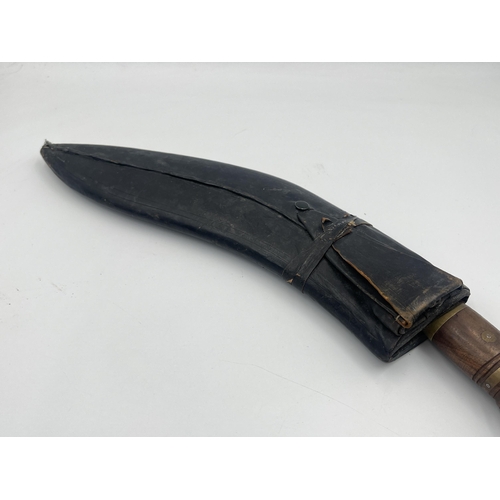 2232A - A vintage Kukri knife with leather sheath and brass and mahogany handle