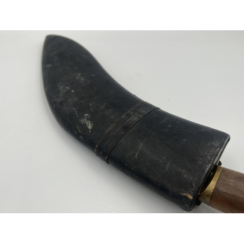 2232A - A vintage Kukri knife with leather sheath and brass and mahogany handle