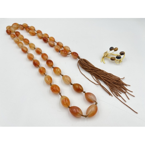 2333 - Two pieces of jewellery, one amber agate beaded necklace and one gilt metal and tigers eye brooch