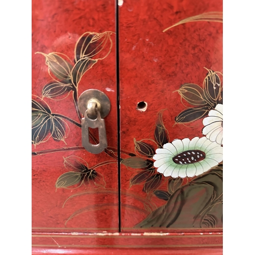 179 - An Oriental red lacquered two door cabinet - approx. 61cm high x 61cm wide x 40cm deep