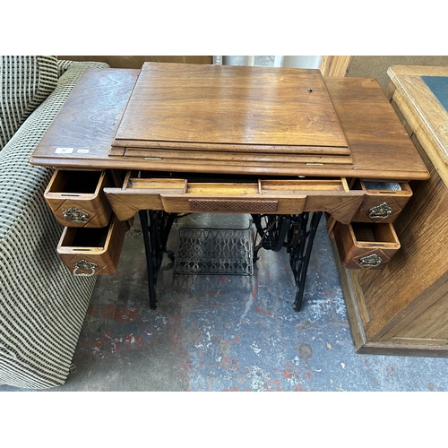 205 - A late 19th/early 20th century Singer walnut and cast iron treadle sewing machine base - approx. 77c... 