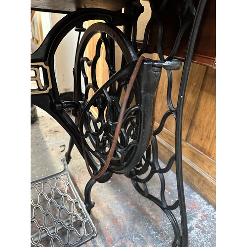 205 - A late 19th/early 20th century Singer walnut and cast iron treadle sewing machine base - approx. 77c... 