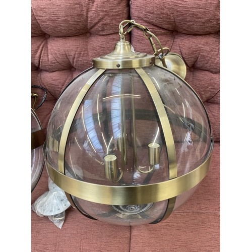 202 - A pair of Laura Ashley Odiham 3691112 brass and glass three branch sphere pendant lights