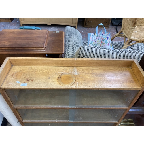 212 - A mid 20th century oak three tier bookcase with six glass sliding doors