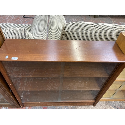 215 - A mid 20th century Herbert E. Gibbs teak three tier bookcase with two glass sliding doors - approx. ... 