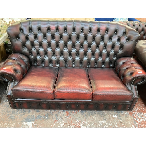 223 - An oxblood leather Chesterfield wingback three seater sofa