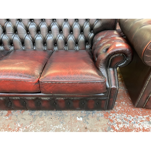 223 - An oxblood leather Chesterfield wingback three seater sofa