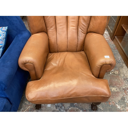 227 - A Georgian style tan leather wingback armchair on ball and claw supports