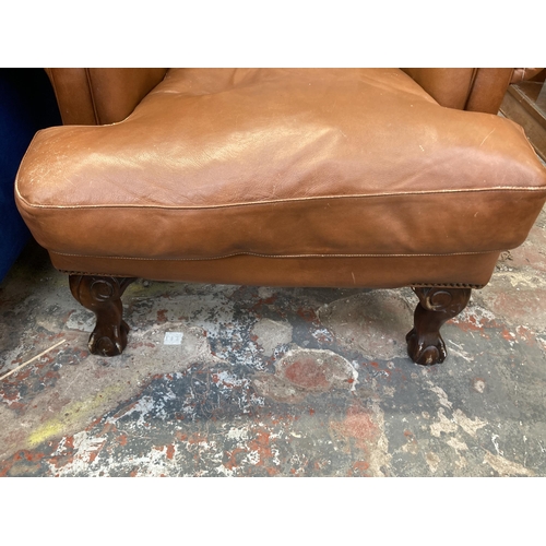 227 - A Georgian style tan leather wingback armchair on ball and claw supports