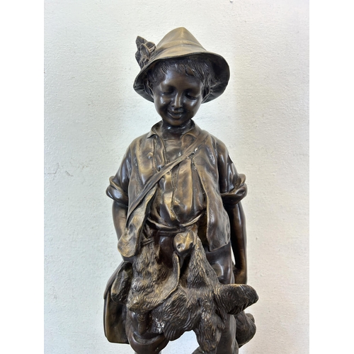 572 - An early/mid 20th century chalkware and bronzed statue of a young boy hunting game - approx. 54cm hi... 