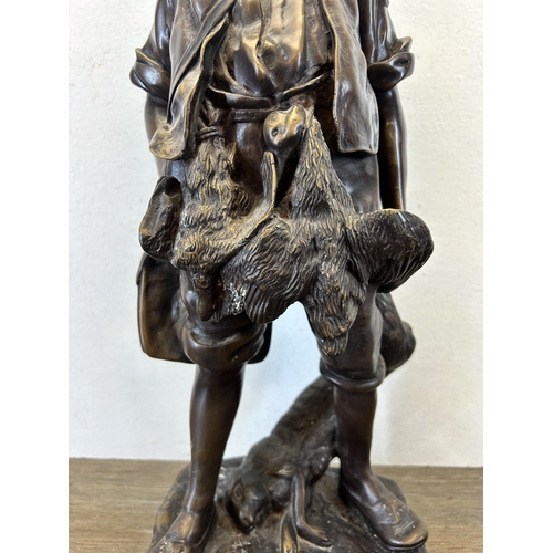 572 - An early/mid 20th century chalkware and bronzed statue of a young boy hunting game - approx. 54cm hi... 