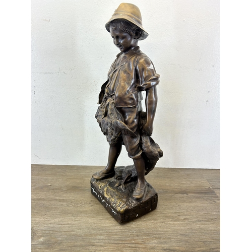 572 - An early/mid 20th century chalkware and bronzed statue of a young boy hunting game - approx. 54cm hi... 